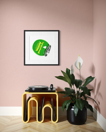 A framed art print featuring a green vinyl record with the text 'Pleasant Valley' is displayed on a dusty pink wall above a yellow record stand with records and a potted plant.